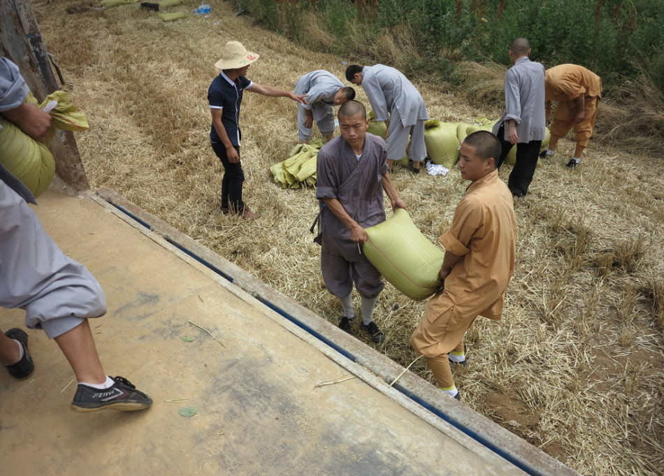 武僧將打包后的糧食集中至運(yùn)輸車輛上。