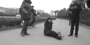 鄭大姐坐在地上，警方趕到進行施救。（視頻截圖由警方提供）