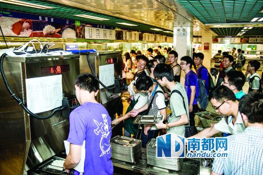 昨日，華南理工大學(xué)一食堂內(nèi)，學(xué)生們正在使用新安裝的自動(dòng)打飯機(jī)打飯。中新社發(fā)