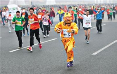 長(zhǎng)安街，一名打扮成孫悟空的參賽者在北馬隊(duì)伍里飛奔。 本版攝影/新京報(bào)記者 吳江 李飛 王嘉寧 吳江