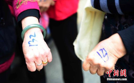 圖為10月28日，在江西九江市一家羊絨皮草服裝服飾博覽會現(xiàn)場，老人們正在頂著寒風(fēng)排隊等待領(lǐng)取10元代金劵。