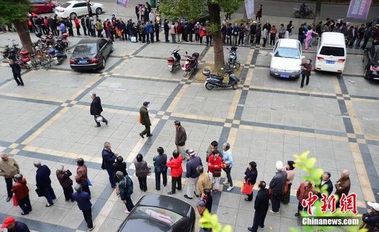 圖為10月28日，在江西九江市一家羊絨皮草服裝服飾博覽會現(xiàn)場，老人們正在頂著寒風(fēng)排隊等待領(lǐng)取10元代金劵。