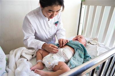 昨日，北京兒童醫(yī)院，護(hù)士為即將出院的被扎鋼針女嬰檢查傷口恢復(fù)情況。記者 高瑋 攝