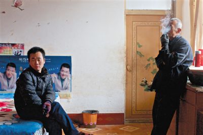 父親抽煙，兒子不語(yǔ)。逃跑的越南新娘，給袁迎賓父子帶來(lái)的是失落。新京報(bào)記者 周崗峰 攝