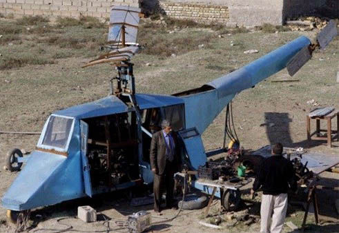 哈蒂姆·卡迪姆·薩爾曼正與工人交談，背后就是他正在制造的直升機(jī)