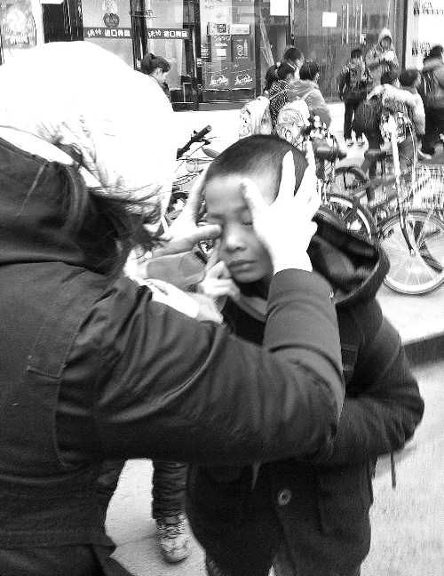 春天風(fēng)沙大，一孩子被風(fēng)沙瞇了眼