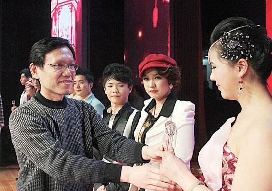 2013年2月1日，《對(duì)9當(dāng)歌》總決賽在鄭州開(kāi)唱。圖為東方今報(bào)副社長(zhǎng)胡楊為選手頒獎(jiǎng)